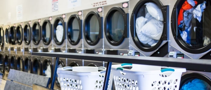 Row Of Washing Machines With Laundry Baskets Min